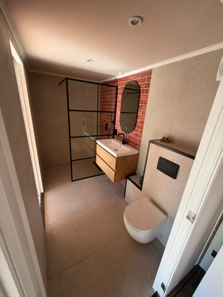 Nieuwe badkamer met hangtoilet, inloopdouche, zwevend meubel en rode steenstrips in Apeldoorn