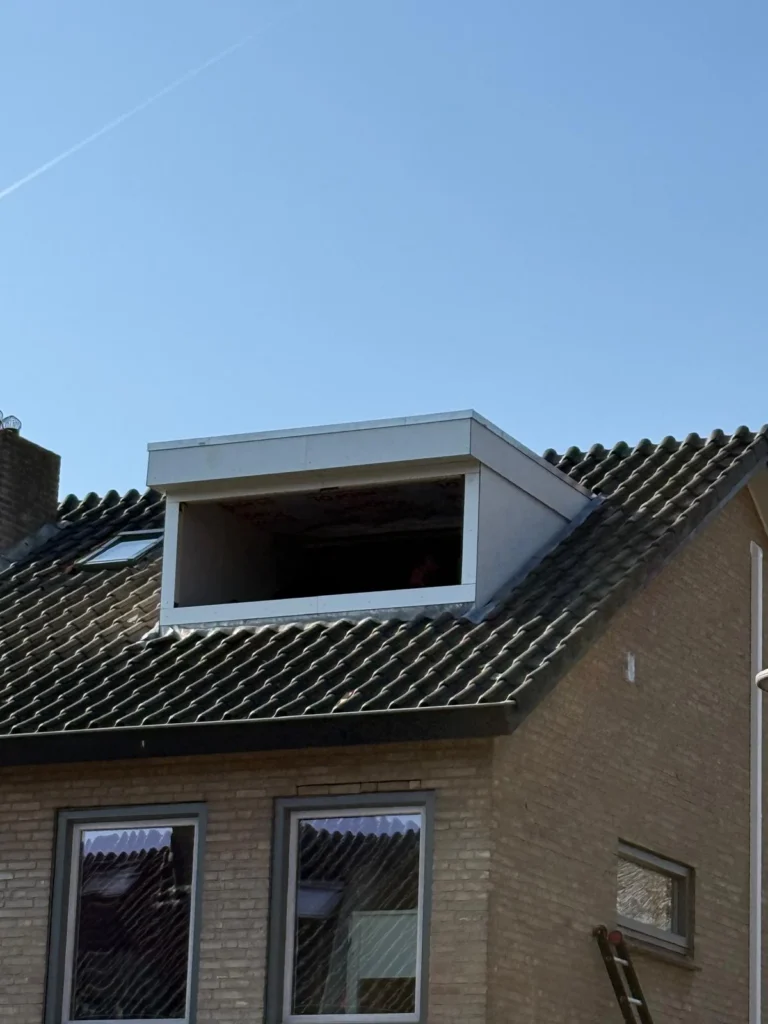 Nieuwe dakkapel met witte afwerking op een pannendak, kozijn nog open in Apeldoorn