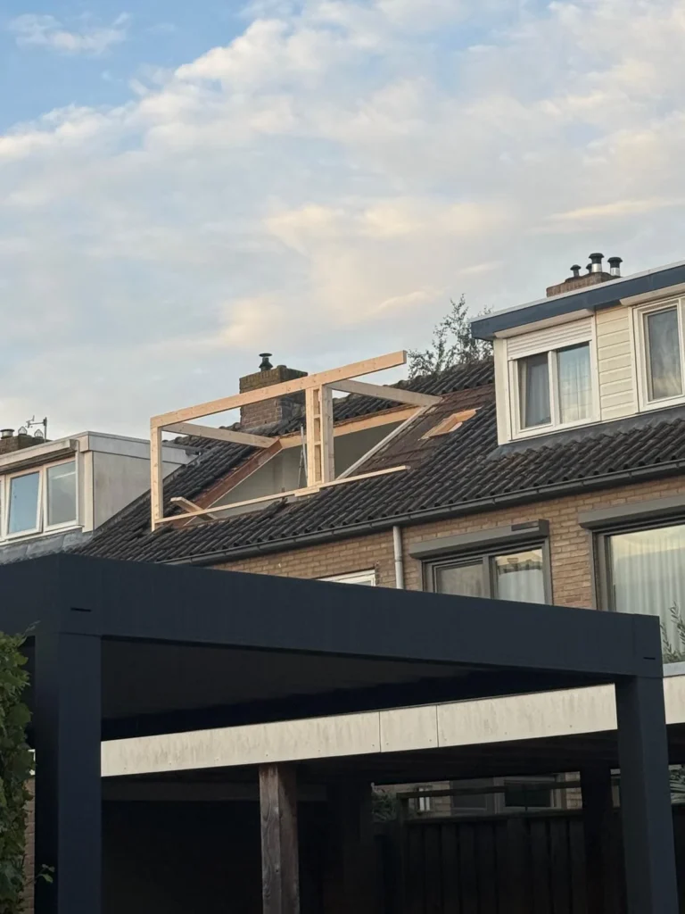 Houten frame voor een nieuwe dakkapel op het pannendak van een rijwoning in Beekbergen