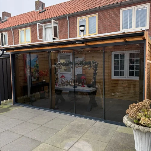 Overkapping met glazen schuifwanden aan de achterzijde van een rijtjeshuis in Apeldoorn